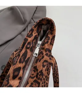 Detail of smooth metal zipper closure and soft leopard print fabric on tote bag