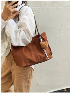 Brown suede tote bag with plush bear charm and white shirt model scene