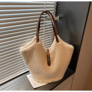 Detailed shot of beige faux fur tote bag with brown leather handles and silver metal clasp