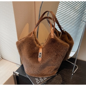 Detail of soft brown faux fur tote bag with leather handles and silver metal clasp closure