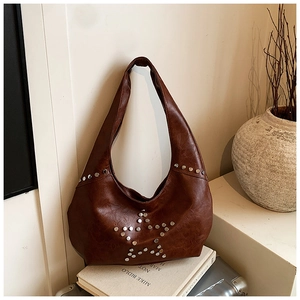 Detailed view of brown retro underarm bag with silver rivet star pattern and faux leather texture