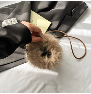 Close-up of khaki faux fur crossbody phone bag with slender brown shoulder strap