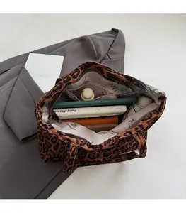 Spacious interior of leopard print tote bag holding tablet, books and wallet