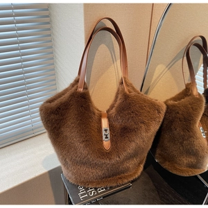 Detail of plush brown faux fur tote bag with leather handles and metal lock closure
