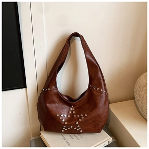 Detail of silver metal rivets in star shape on brown vintage leather shoulder bag