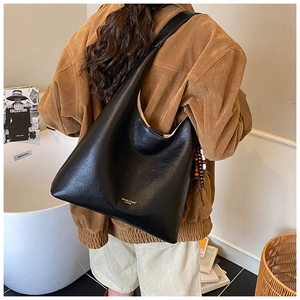 Détail du grand sac cabas noir rétro avec lettrage doré et pendentif en perles de bois