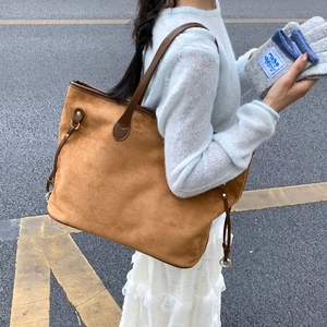 Detailed view of caramel suede tote bag with leather handles and knit gloves set
