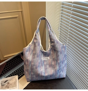 Detailed macro view of nebula print tote bag with white woven label and star pattern