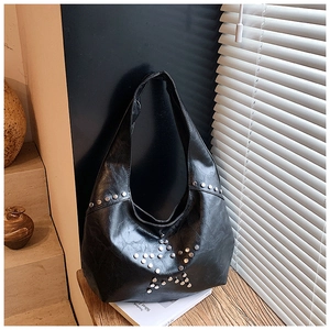 Close-up of silver metal rivets forming a star pattern on a black faux leather tote bag