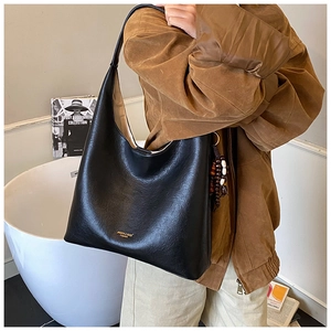 Gros plan sur un sac cabas noir en cuir grainé avec détail de perles en bois rétro