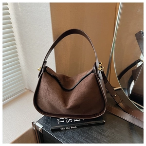 Détail du sac à bandoulière en daim marron avec lanière en cuir et boucles dorées
