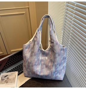 Close-up of a large tote bag with abstract patterns and KISS YOURSELF woven label