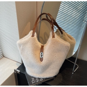 Detail of beige faux fur tote bag featuring brown leather straps and silver metal twist lock