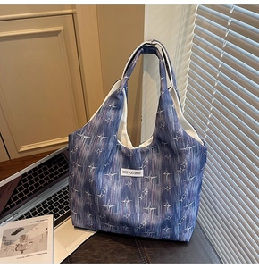 Detail of navy canvas tote bag featuring star pattern and white text patch