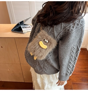 Detail of a brown plush crossbody bag with cartoon face on a warm winter outfit
