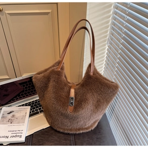 Detail of plush brown faux fur tote bag with leather handles and silver metal buckle