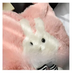 Gros plan sur la peluche rose douce avec détail de tête de lapin blanc et ruban rayé élégant