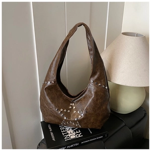 Detail view of retro brown shoulder bag with silver rivet star pattern on the leather