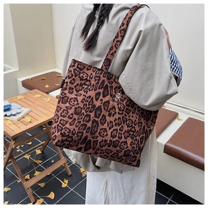 Detailed view of the leopard print tote bag texture and soft fabric shoulder strap