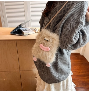 Detail of cute brown plush monster crossbody bag with soft eyes and pink feet on model