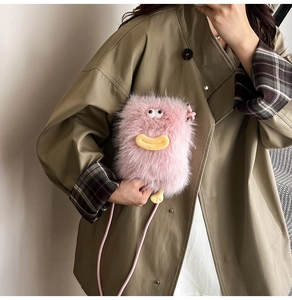 Detail of pink faux fur crossbody bag with cute 3D cartoon monster face design