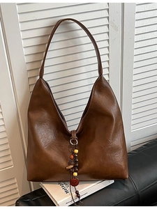 Vintage brown leather hobo bag with wooden bead tassel and large shoulder strap