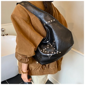 Detail of vintage black shoulder bag with silver rivet studs and soft leather texture
