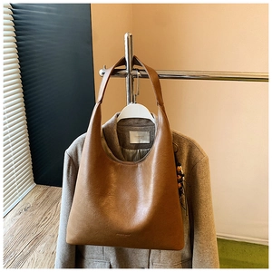 Gros plan du fond du sac cabas marron vintage avec texte doré sur cuir texturé