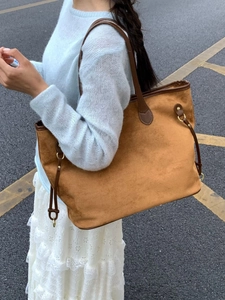 Large brown faux suede tote bag for women with leather straps in an outdoor street setting