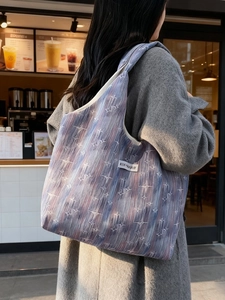 Starry stripe canvas tote bag with 'KISS YOURSELF' tag shown in a street lifestyle view