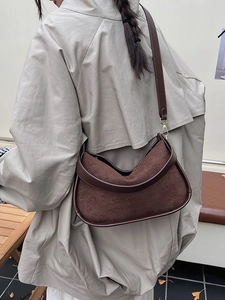 Sac hobo marron en daim pour femme associé à un trench-coat classique pour l'automne