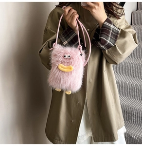 Close-up of pink plush monster crossbody bag featuring big eyes and soft faux fur texture