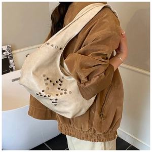 Detail of cream hobo bag with silver star rivet studs and textured faux leather finish