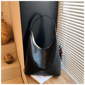 Vue détaillée du sac hobo noir mat avec texture fine et pendentif en perles de bois
