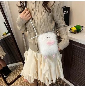 Detail of white faux fur monster crossbody bag worn by model with playful cartoon features