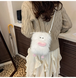 Detail shot of a white fuzzy monster plush crossbody bag with cartoon eyes and pink lips