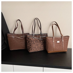 Détails de trois sacs cabas à imprimé léopard avec différents motifs et logo métallique