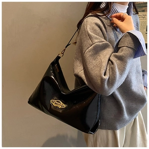 Dettaglio della borsa hobo in pelle lucida nera con logo giallo e tracolla sottile
