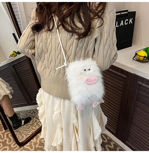 Detail of cute white plush monster crossbody bag with pink lips on a stylish outfit
