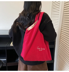Dettaglio della borsa tote in velluto a coste rosso con texture e scritte d'arte