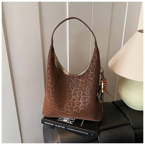 Détail du sac hobo à motif léopard avec texture en daim et breloque à pompon perlé