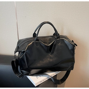 Gros plan du sac fourre-tout en cuir PU noir avec logo de la marque et bandoulière