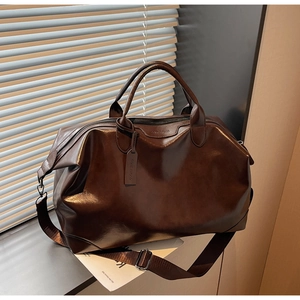 Gros plan du sac cabas en cuir synthétique marron foncé avec poignées et fermeture éclair