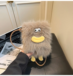 Detail of cute monster plush crossbody bag featuring big eyes and soft brown fur texture