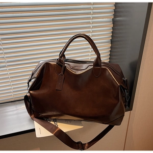 Détail d'un sac cabas en similicuir marron avec étiquette sur un rebord de fenêtre