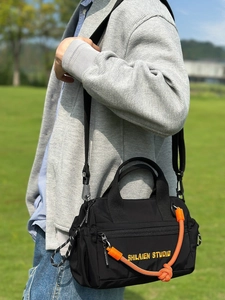 Bolso bandolera de nailon negro a la moda con detalle de cuerda naranja y correa