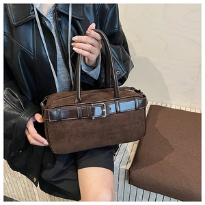 Close-up of dark brown suede bucket bag with leather belt detail and silver buckle