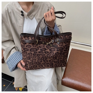 Détail du grand sac cabas imprimé léopard avec bordures en cuir marron et boucles dorées