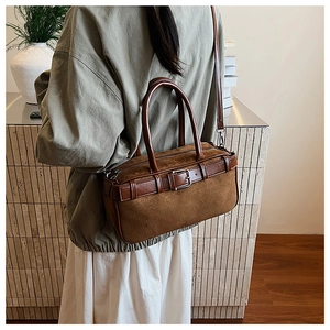 Detailed back view of model wearing a vintage brown suede Boston bag with leather straps