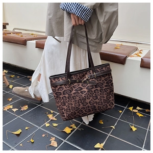 Détail du sac cabas à imprimé léopard avec anses en cuir et boucles dorées chic